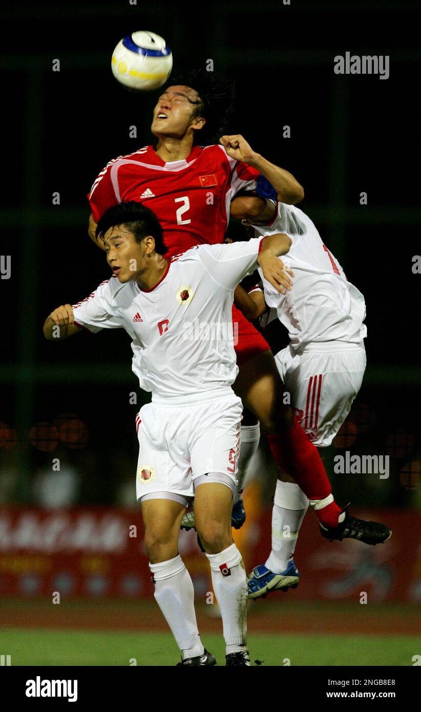 Du Wei of China, top, fights for the ball with Cheng Laihin, front, and ...
