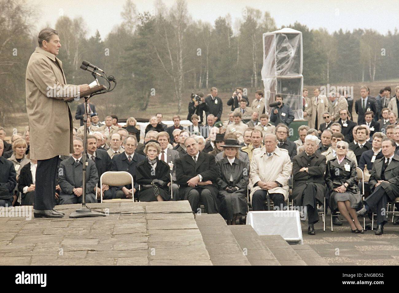 U.S. President Ronald Reagan speaks during ceremonies at the site of the former Bergen-Belsen Nazi concentration camp in West Germany, Sunday, May 5, 1985. President Reagan is on a State visit to honor victims of World War II and the Holocaust and attend ceremonies commemorating the 40th anniversary of the end of World War II in Europe. First lady Nancy Reagan is seated second from left. (AP Photo) Stock Photo