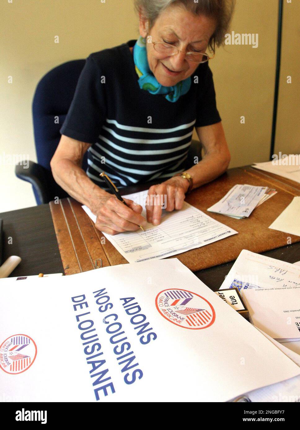 Image showcasing France's Martine Esparbet checks documents at the French association ...