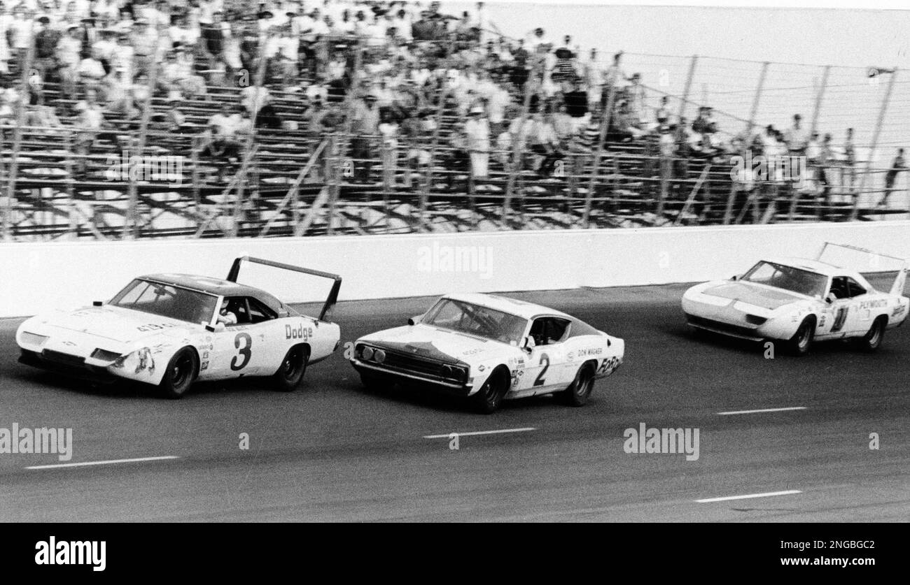 A. J. Foyt, driving the car pictured in the center, is about to pass ...