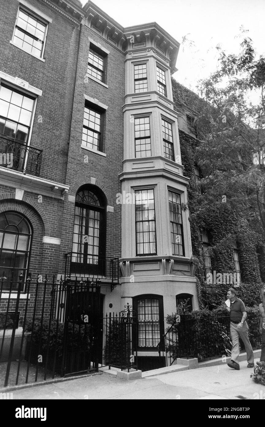 A man walks in front of a townhouse at 142 East 65th Street