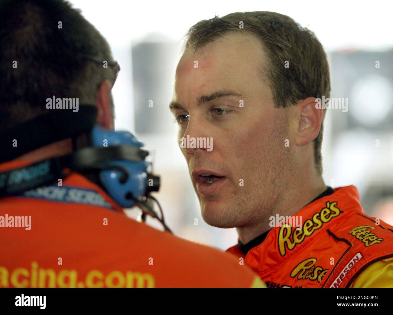 Kevin Harvick talks to a crew member in the garage during Busch practice for Saturday's Carquest