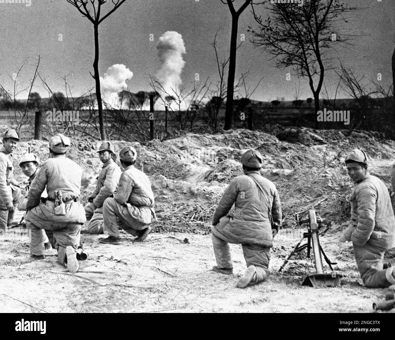 Soldiers of a Chinese Nationalist mortar detachment, watch heavy artillery shells explode short