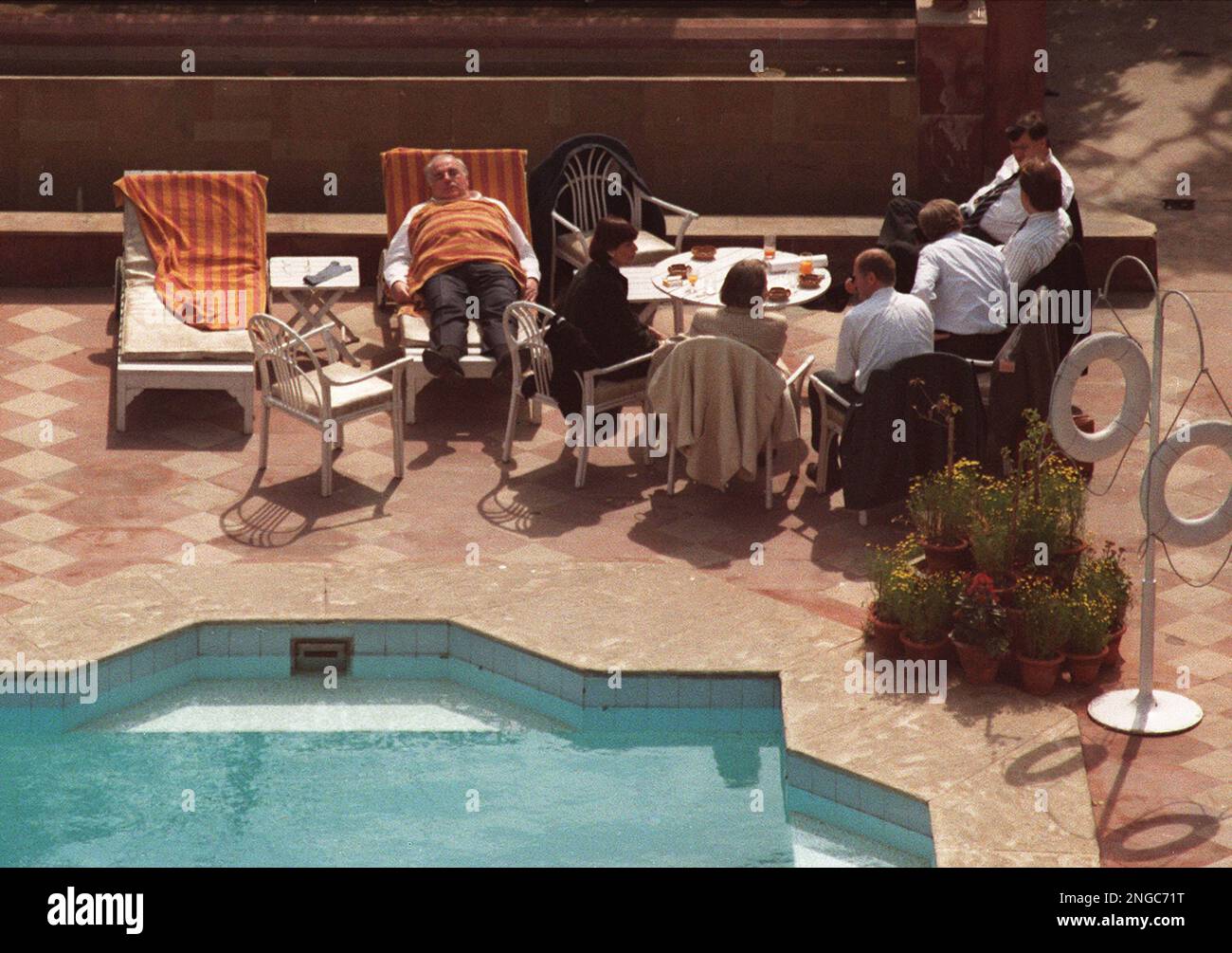 Mit einem Handtuch bedeckt haelt Bundeskanzler Helmut Kohl in einem  Liegestuhl am Swimmingpool in seinem Hotel in New Delhi am Montag, den 22.  Februar 1993, ein Nickerchen. Kohl hielt saich zu einem