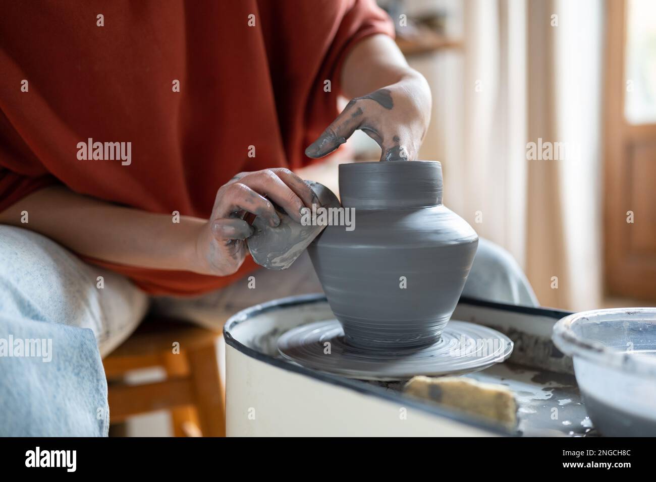 Creating clay formed ceramic art vase or pot on potter wheel in ...