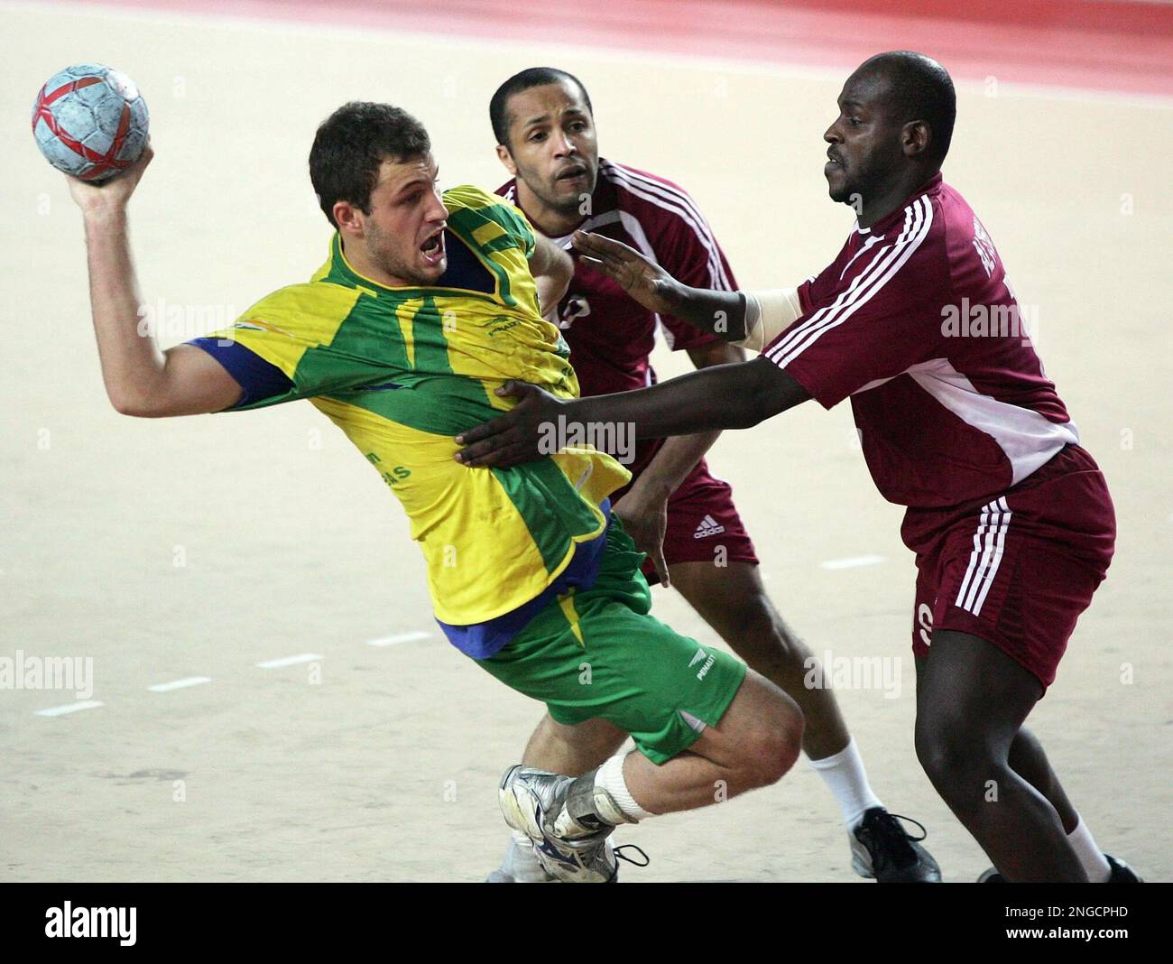 Brazil handball player Danilo Paulino da Silva, left, throws the ball  against Qatar's handball players Ahmed Saad Al Saad, center, and his  compatriot Borhan Saleh Al Turki during the group D match