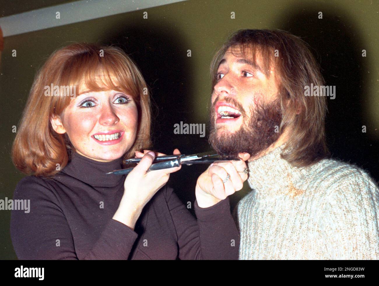 British pop singer Lulu uses a pair of scissors to cut off her husband Maurice Gibb's beard in their north London flat, Feb. 1, 1970. Gibb, a member of The Bee Gees,