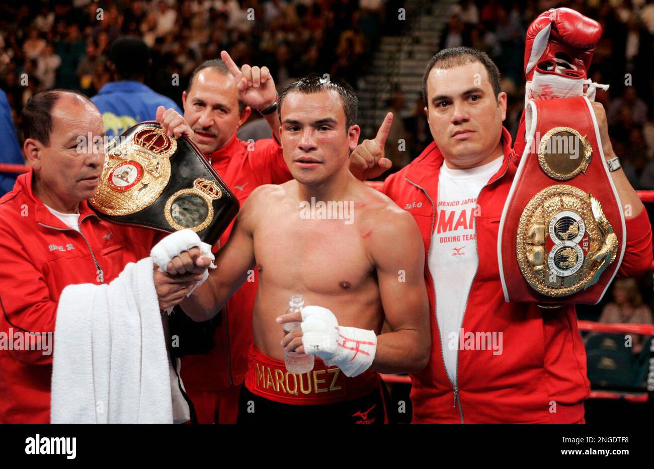 Juan Manuel Marquez, of Mexico, is shown with his belts and members of his  camp after defeating Orlando Salido, of Mexico, in their WBA/IBF  featherweight title fight on Saturday, Sept. 18, 2004,, image size:1300x932