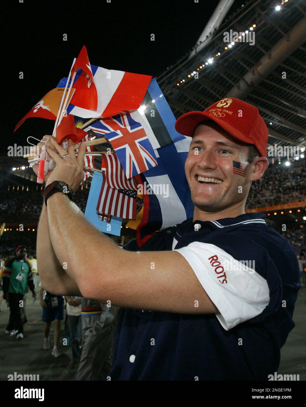 Kent Smack, member of the USA rowing team carries flags from various nations during the closing