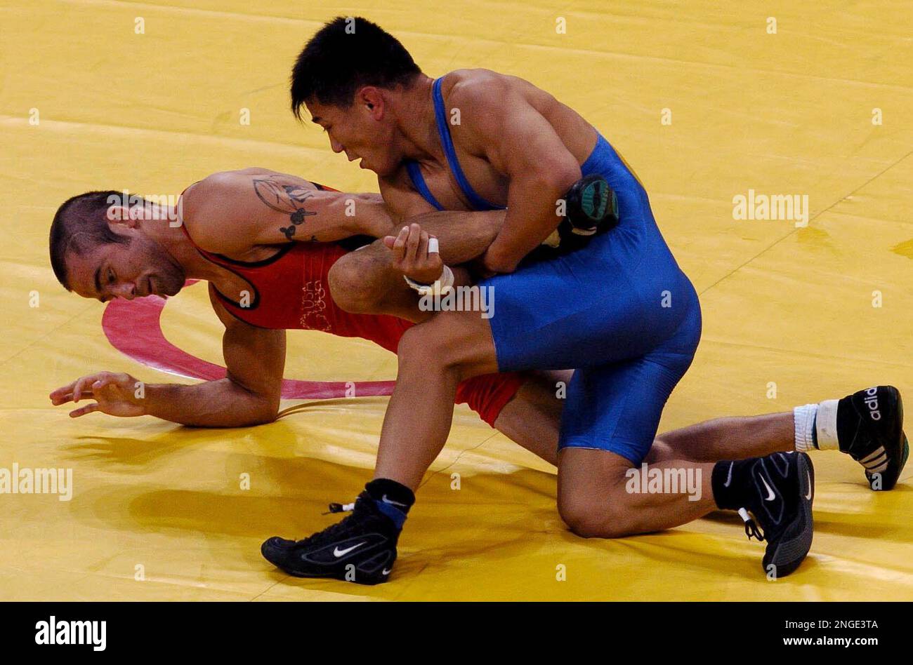 Ly Zhengyu of China, blue, and Stephen Abas, from USA wrestle during a qualification bout for the mens freestyle 55kg wrestling at the 2004 Olympic Games in Athens, Friday, Aug