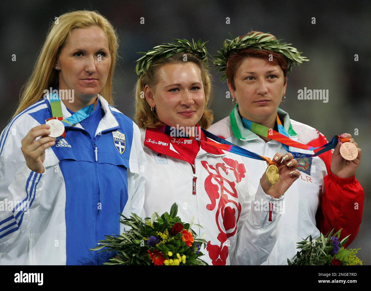 Natalya Sadova, center, of Russia, won the discus gold medal with a throw of 67.02 meters at the 2004 Olympic Games Sunday, Aug. 22, 2004 in Athens, Greece. Anastasia Kelesidou, left, of Greece, won the silver, and Irina Yatchenko of Belarus took the bronze. (AP Photo/David J. Phillip) Stock Photo