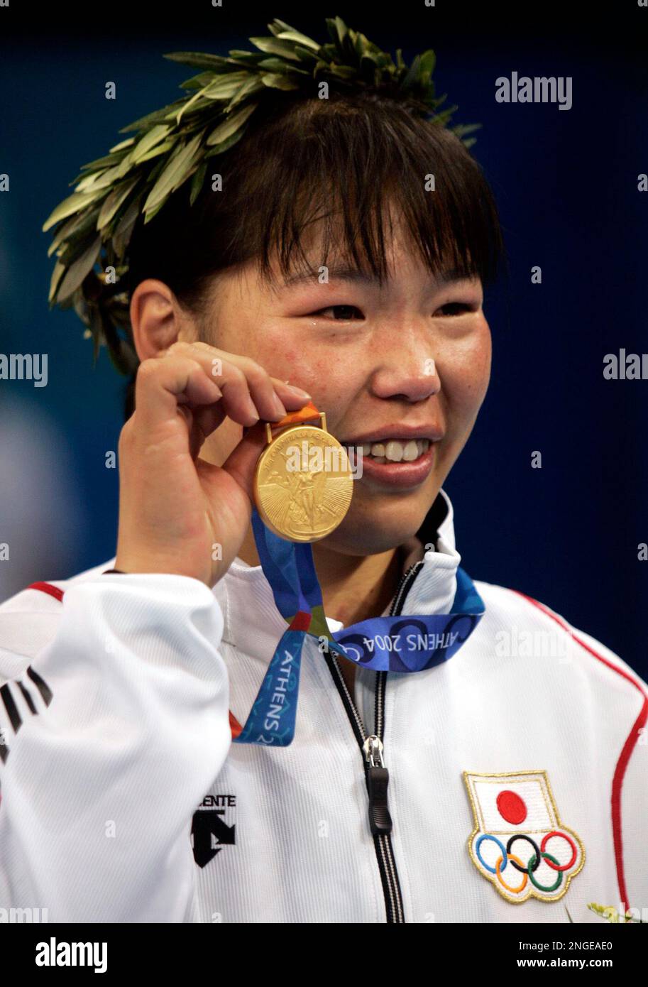 Japan's Anno Noriko shows off her gold medal for HalfHeavy Judo at the
