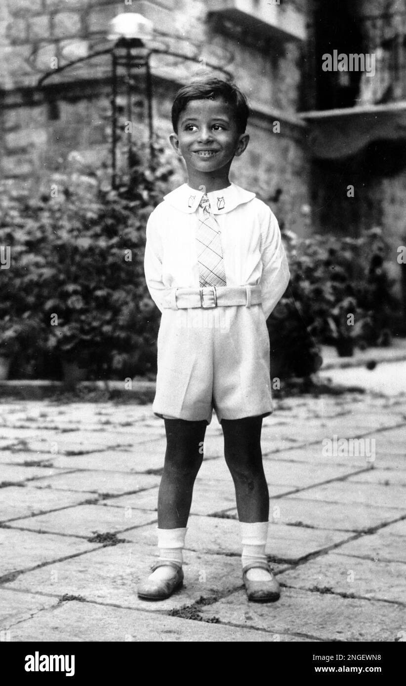 Young King Faisal II of Iraq poses in the garden whilst on holiday in