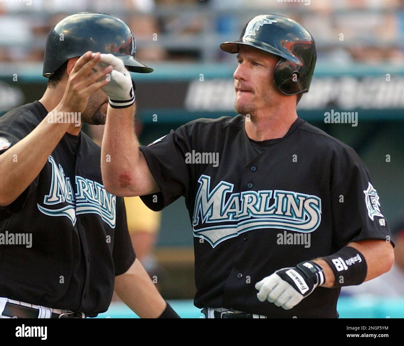 Florida Marlins' Jeff Conine, right, is congratulated by teammate Mike  Lowell after connecting on a two-run home run against Atlanta Braves  pitcher Mike Hampton during the first inning Saturday, April 24, 2004