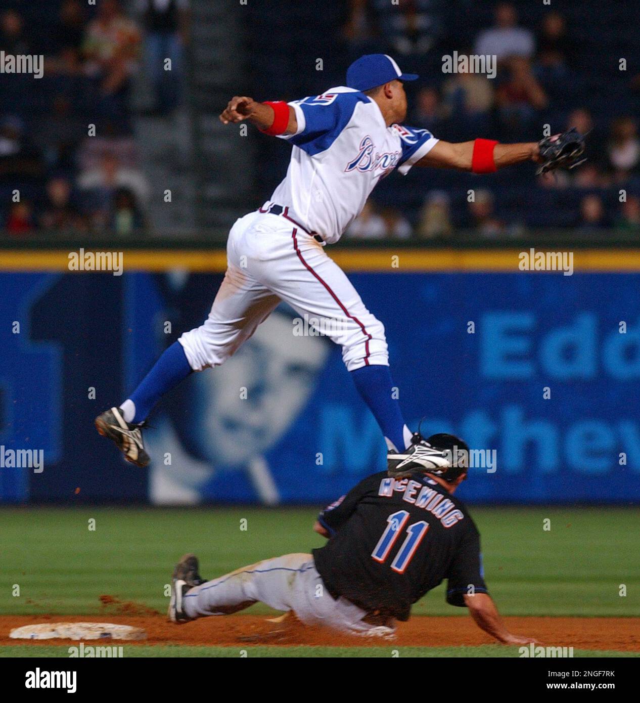Atlanta Braves shortstop Rafael Furcal follows through on a throw to first  base for a double play in the ninth after tagging out New York Mets' Cliff  Floyd as second baseman Marcus
