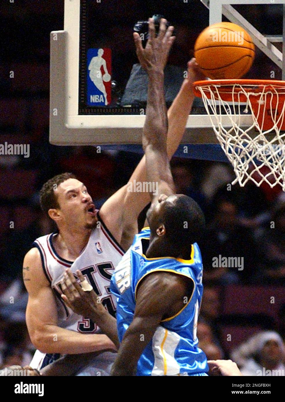 New Jersey Nets Aaron Williams left dunks the ball over Denver Nuggets Francisco Elson during the second quarter Wednesday night March 10 2004 in East Rutherford N.J. AP Photo Bill Kostroun Stock