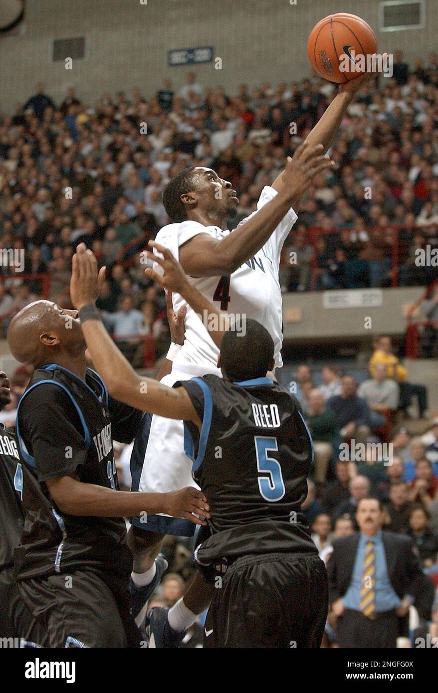 Connecticut's Ben Gordon goes up above Georgetown's Gerald Riley, left ...