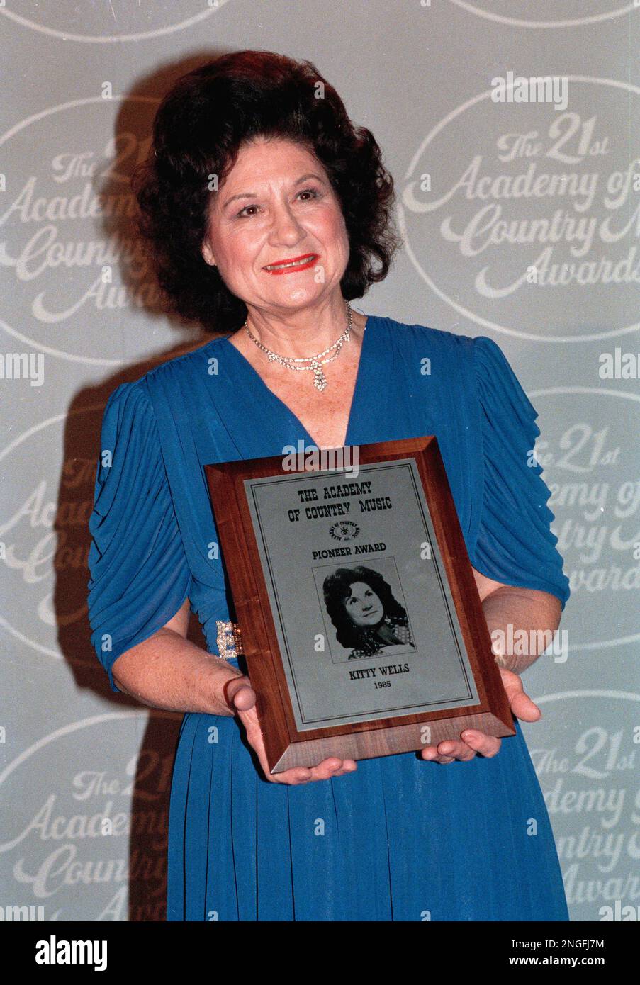 Country singer Kitty Wells poses with the Pioneer Award, presented to her at the annual Academy