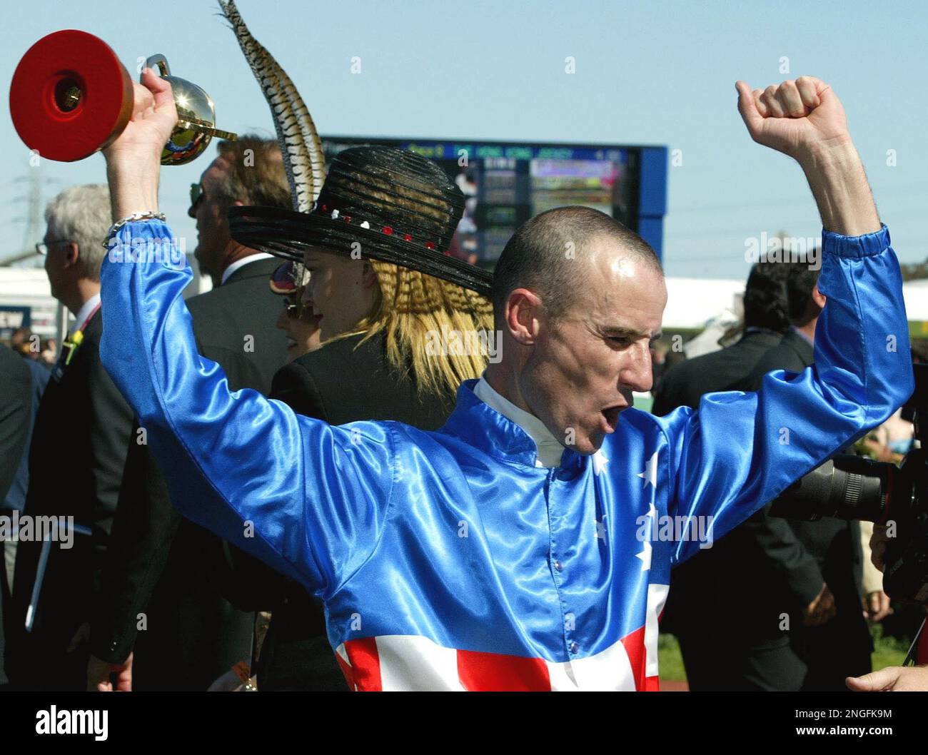 Jockey Glen Boss raises his arms in celebration after riding Makybe