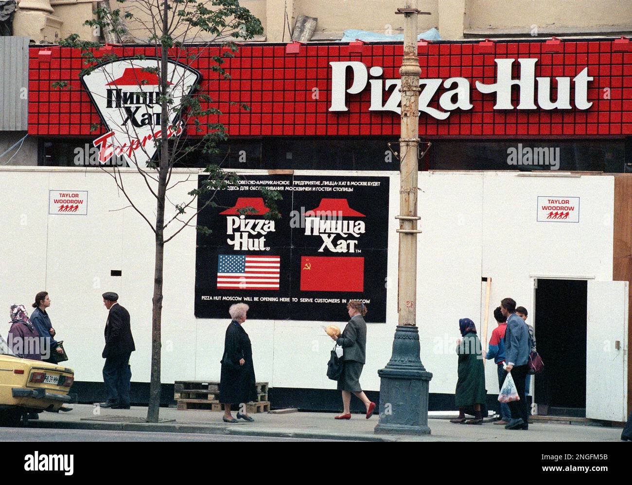 People walk on Gorky Street past one of two Pizza Hut restaurants under