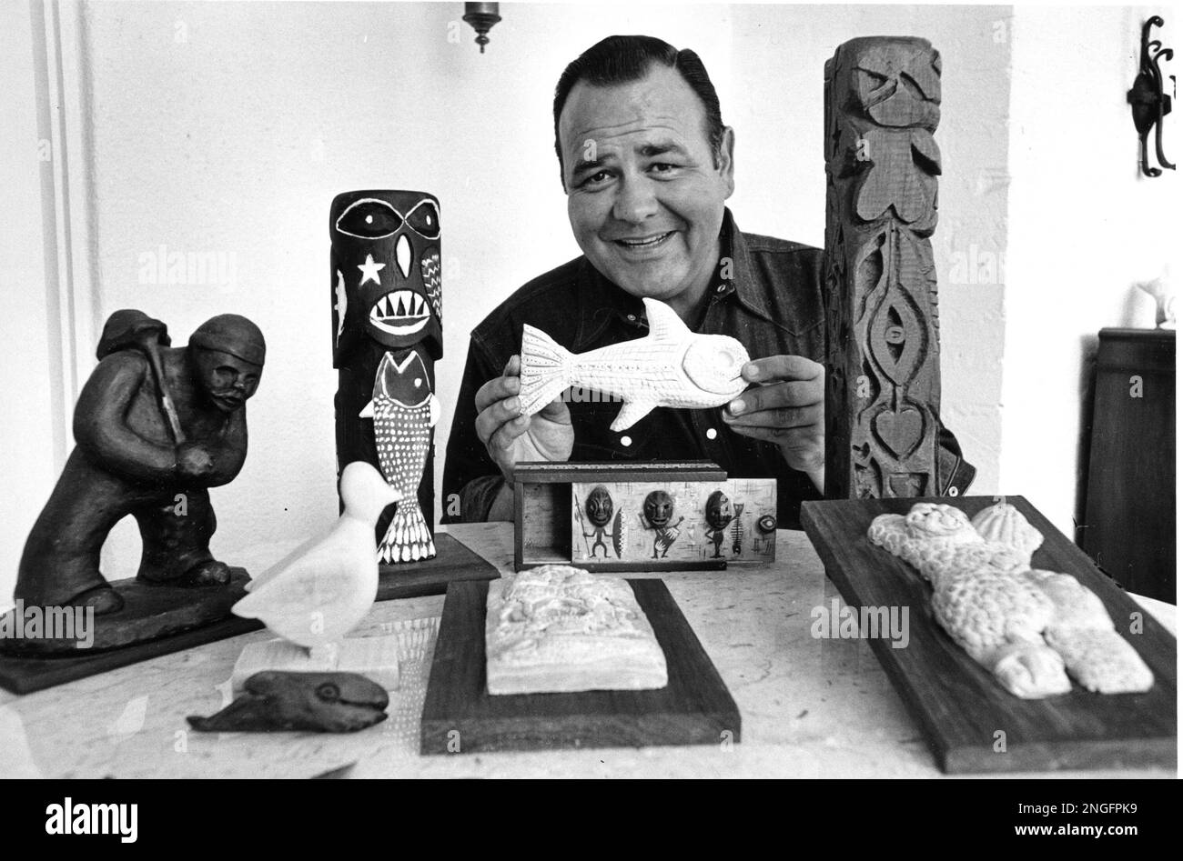 Comedian Jonathan Winters poses with his carvings and sculptures at his