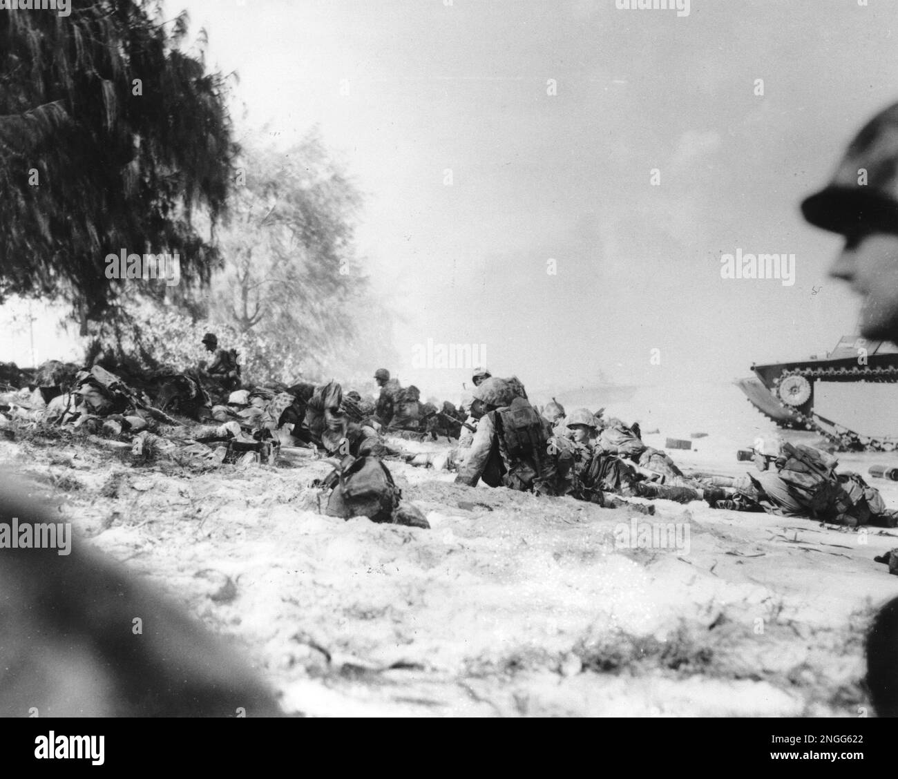 U.S. Marines move up the beach on Saipan under heavy machine gun fire