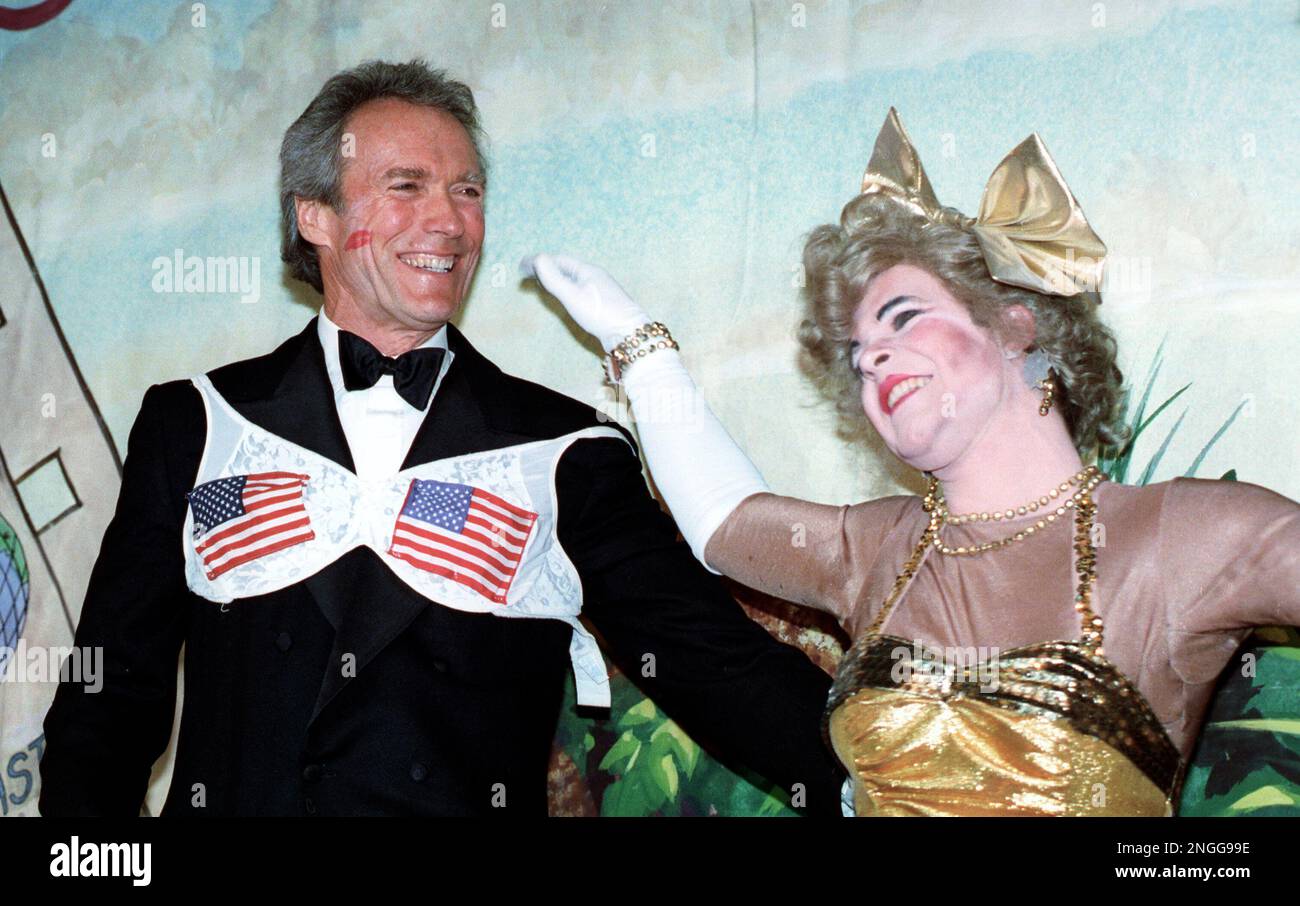 Clint Eastwood wears an American flag bra over his tuxedo and a ruby
