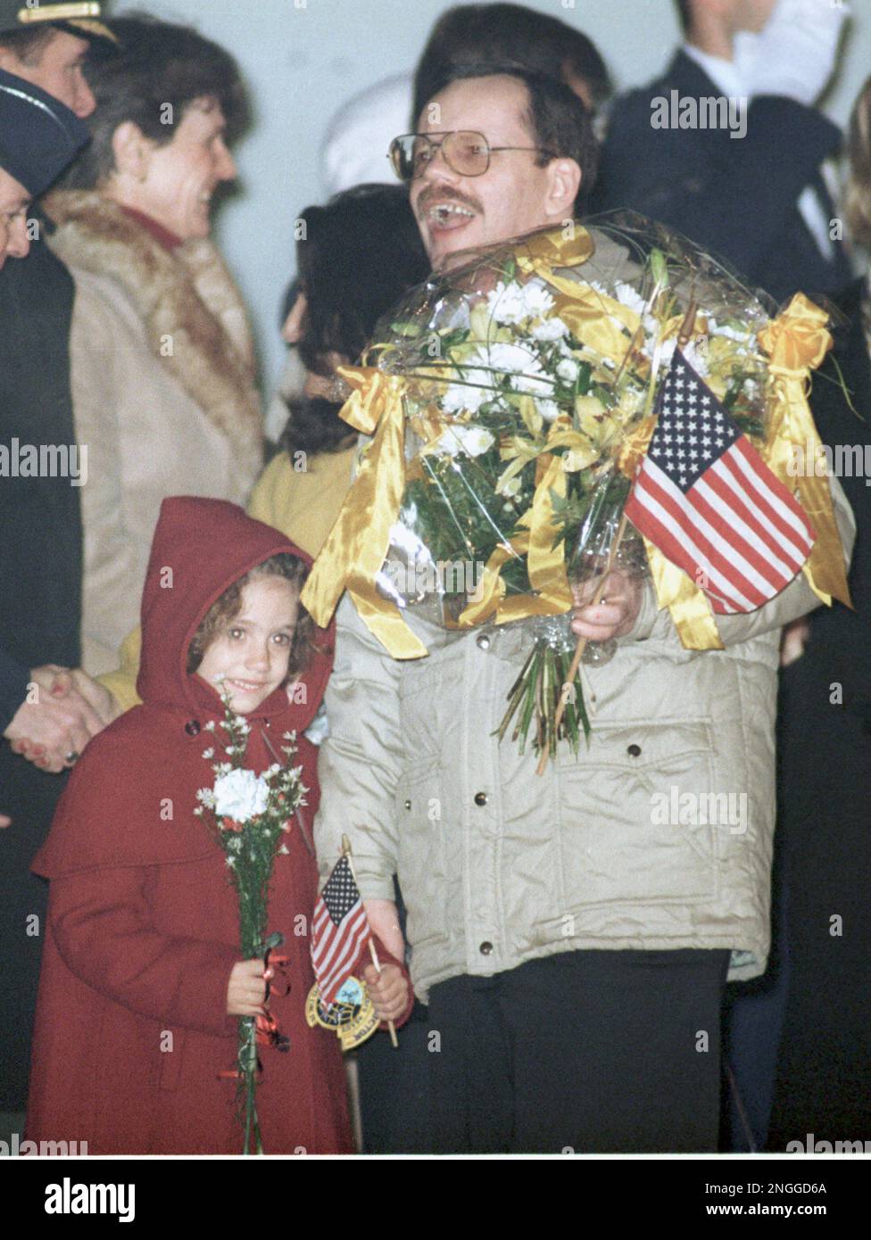 Freed hostage Terry Anderson, accompanied by his daughter Sulome, holds a bouquet of flowers and a small American flag upon arrival at Rheim Main air base outside Frankfurt, Germany, early Thursday, Dec. 5, 1991. Anderson was released Wednesday by his pro-Iranian captors after six-and-a-half years of captivity in Beirut, Lebanon. (AP Photo/Diether Endlicher) Stock Photo