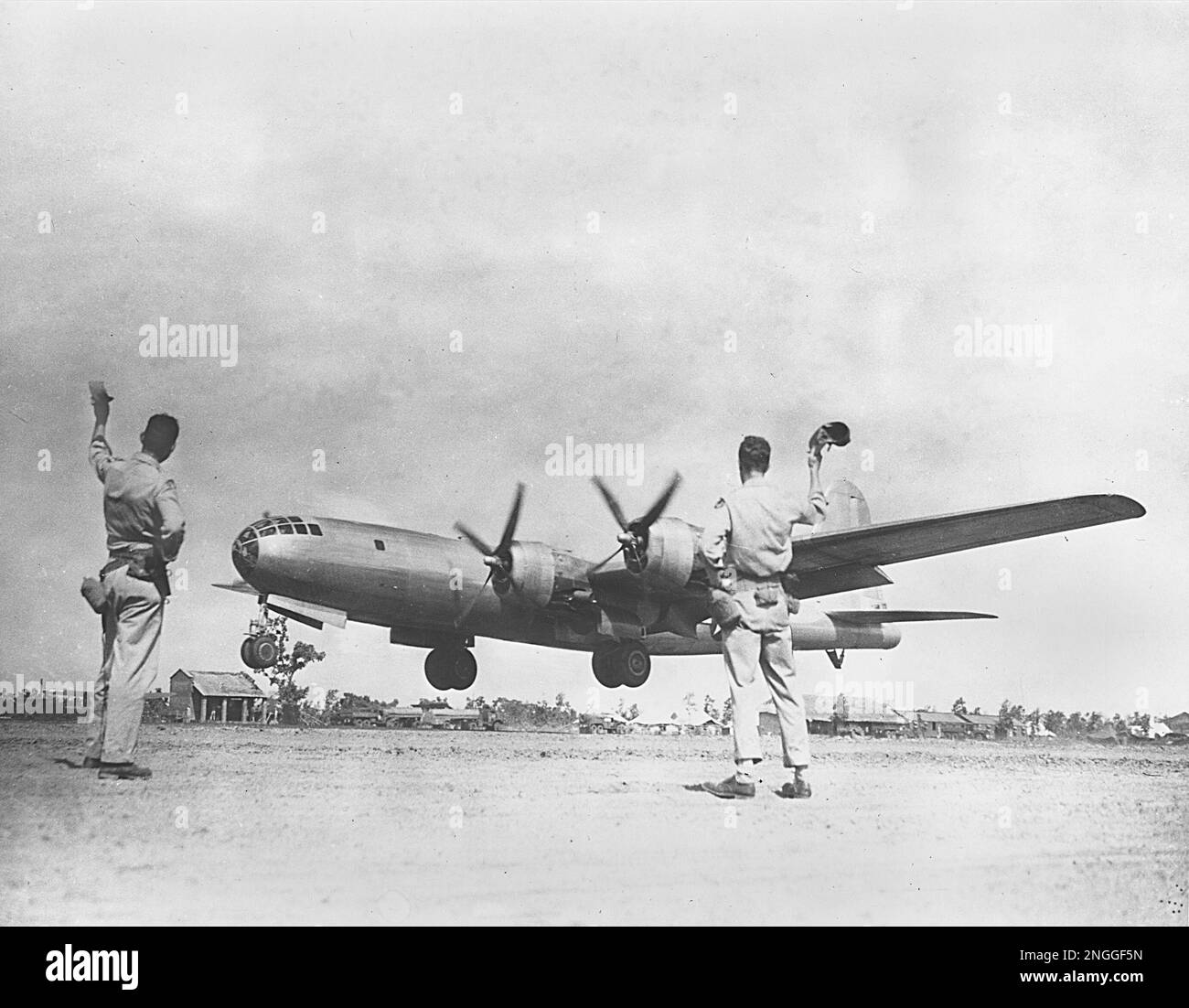 A ground crew waves as the new B29 Superfortress of the 20th Bomber Command takes off from a