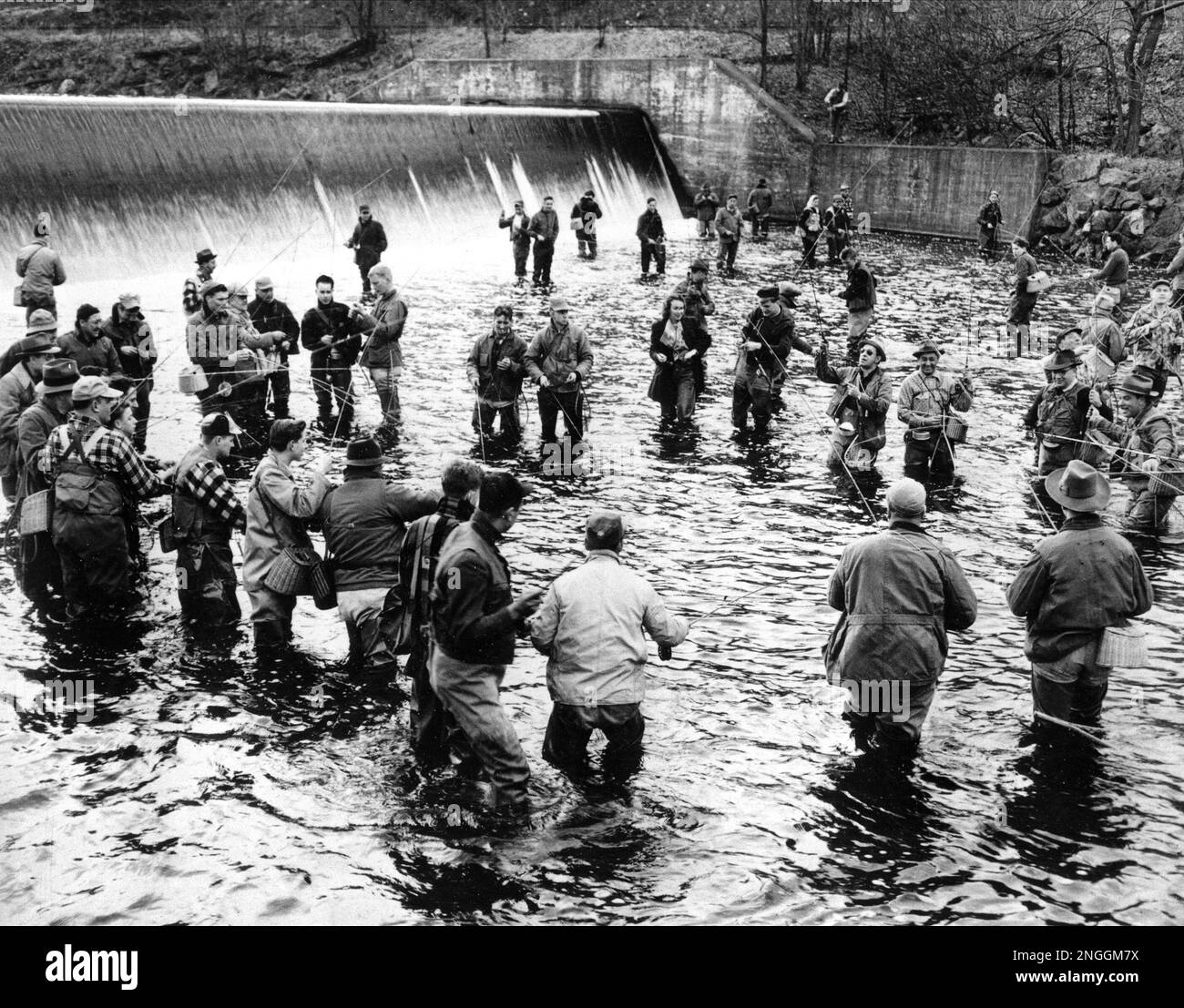 Trout anglers stand in a circle around a deep hole at Saxton's Falls on
