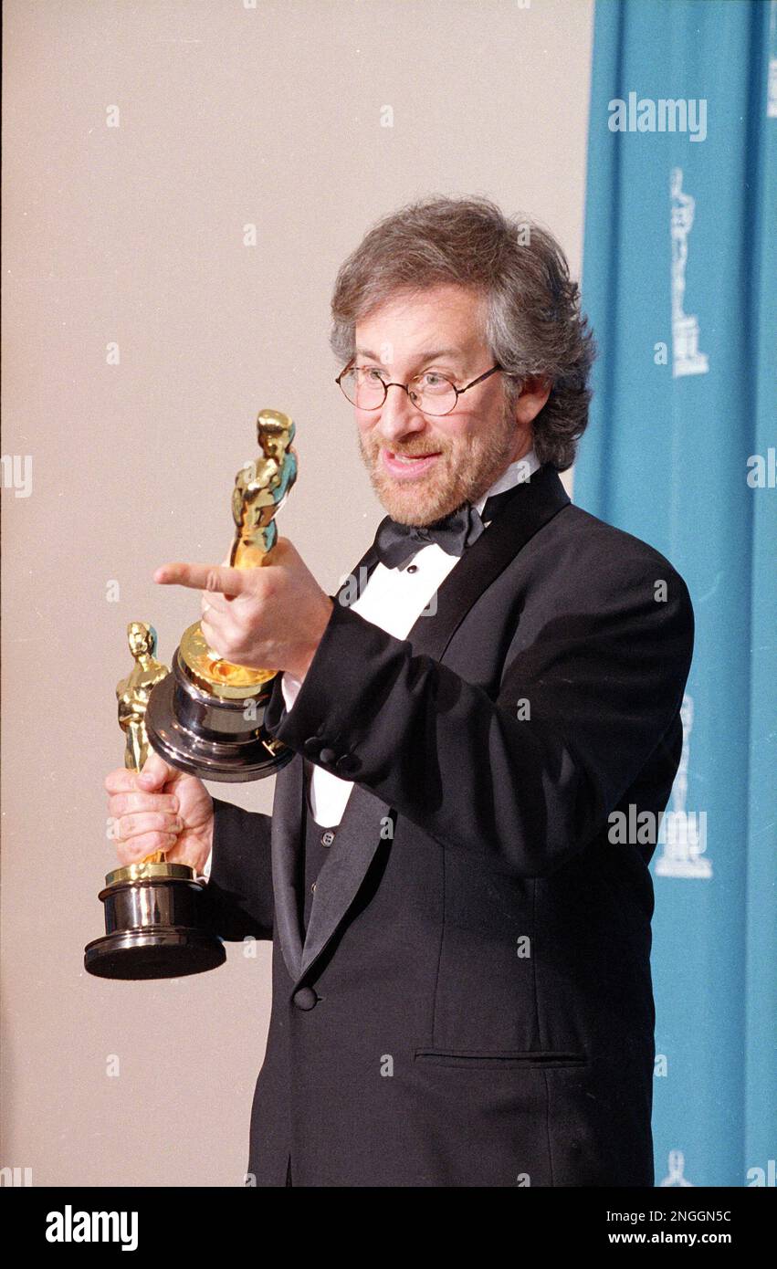 Holding the two Oscars he received for best director, and best picture