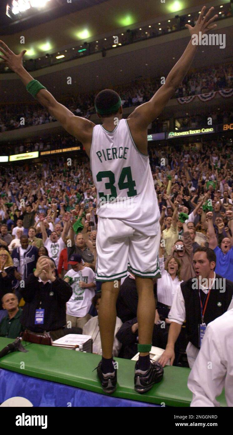 Boston Celtics forward Paul Pierce raises his arms toward the fans after  jumping up on the scorer's table after their come from behind 94-90 win  against the New Jersey Nets in game