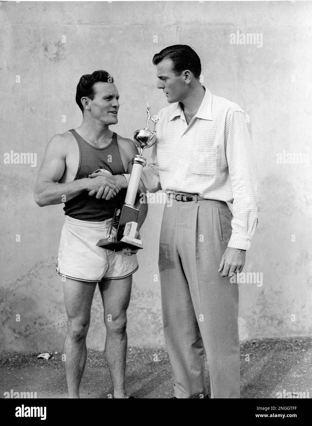 The Rev. Bob Richards, left, of Los Angeles, Ca., receives the decathlon  trophy from Bob Mathias at Bader Field, Atlantic City, N.J., July 3, 1957.  Richards, 28, scored 6,501 points in the