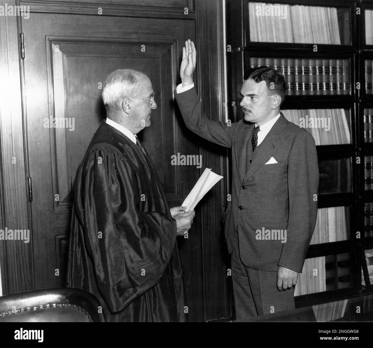Special prosecutor Thomas E. Dewey holds up his right hand as he is