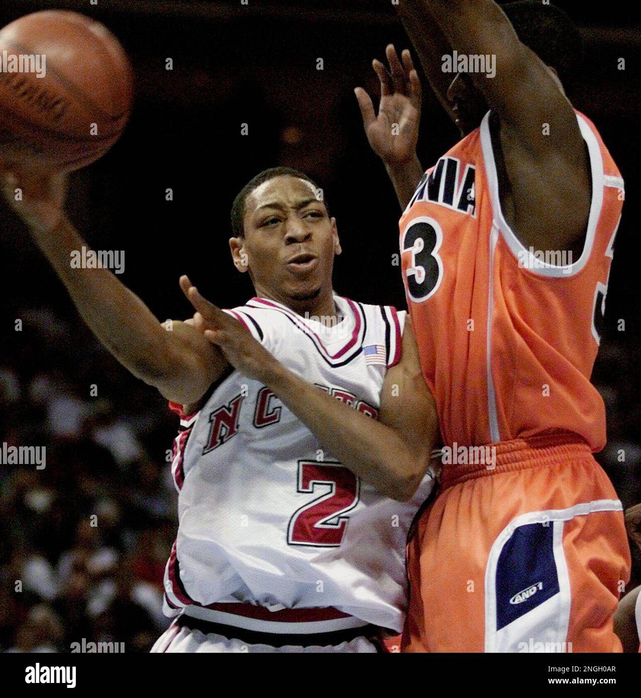 North Carolina State's Anthony Grundy (2) flies past Virginia's Travis Watson late in the second half at the ACC Men's Basketball Tournament Friday, March 8, 2002, in Charlotte, N.C. (AP Photo/Gerry Groome) Stock Photo