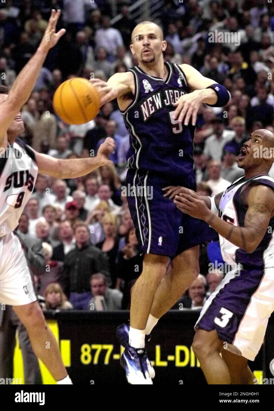 New Jersey Nets guard Jason Kidd (5) passes between Phoenix Suns guard  Stephon Marbury, right, and Dan Majerle during the fourth quarter  Wednesday, March 6, 2002, at America West Arena in Phoenix.