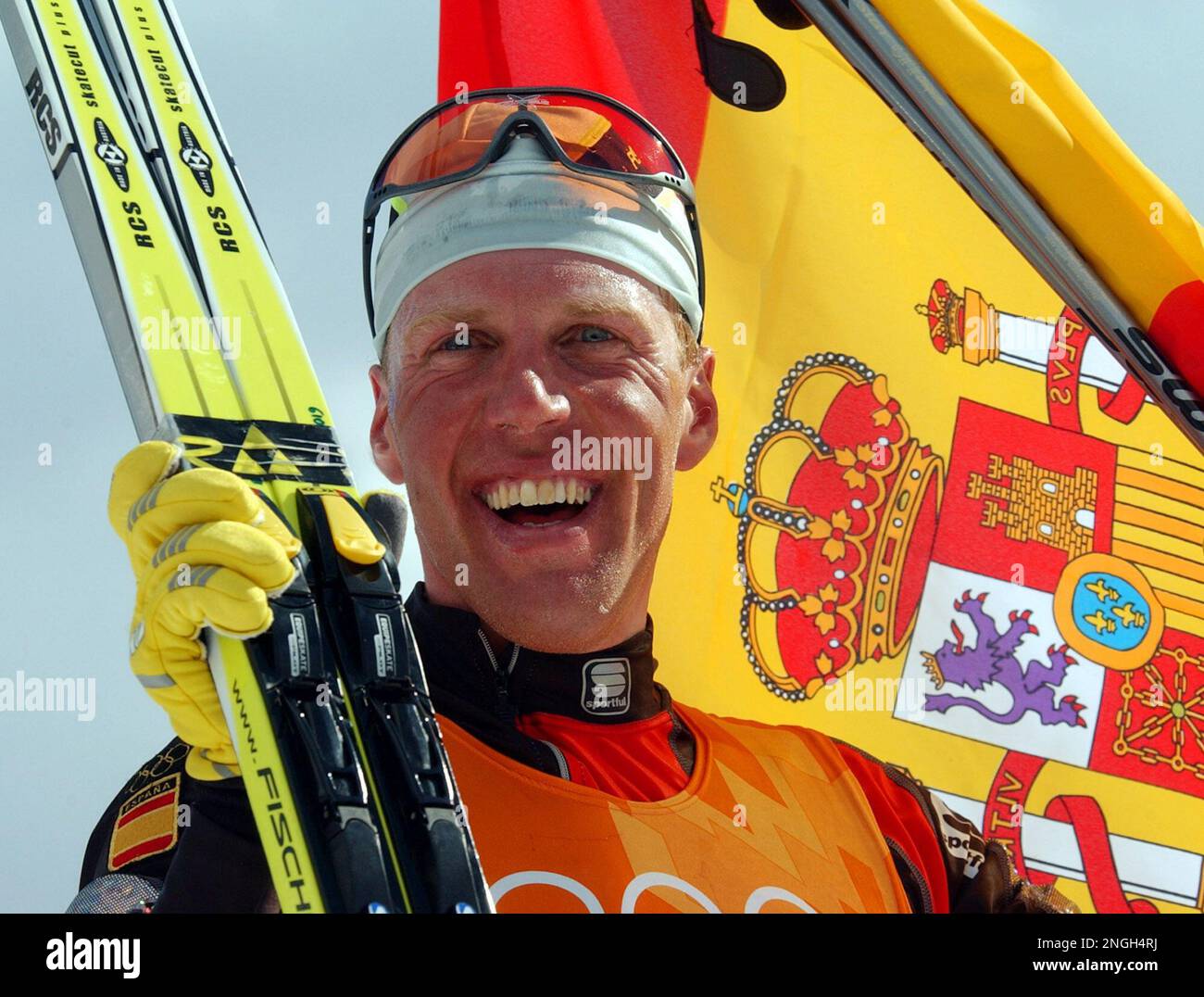 Spain's Johann Muehlegg celebrates with the flag after winning the gold medal in the men's cross
