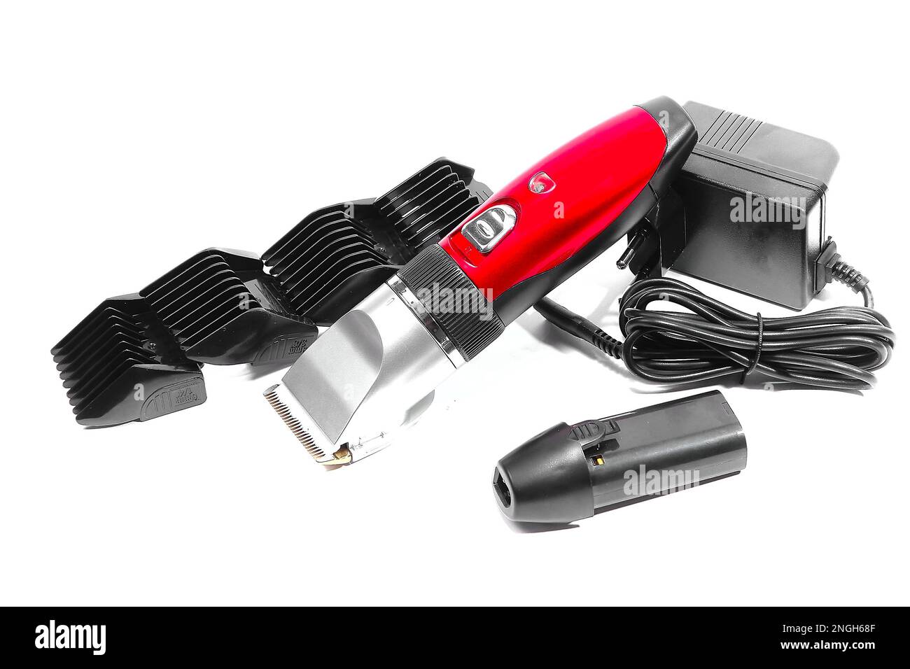 Hair clipper, attachments of different sizes, extra battery, charger in closeup on white