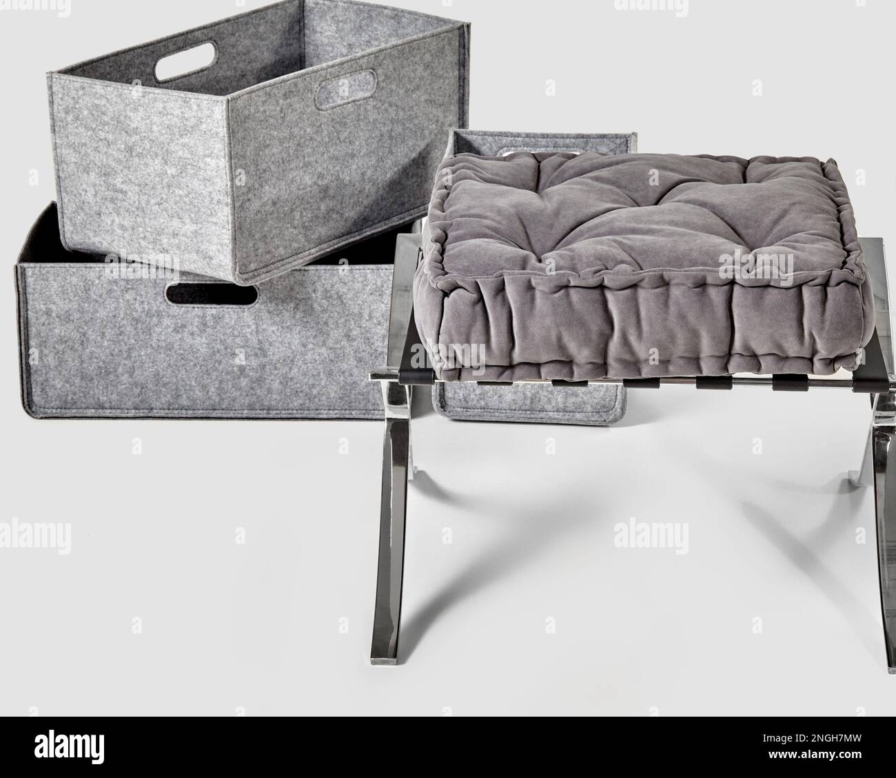 Gray velvet seat cushion on ottoman and felt storage boxes Stock Photo