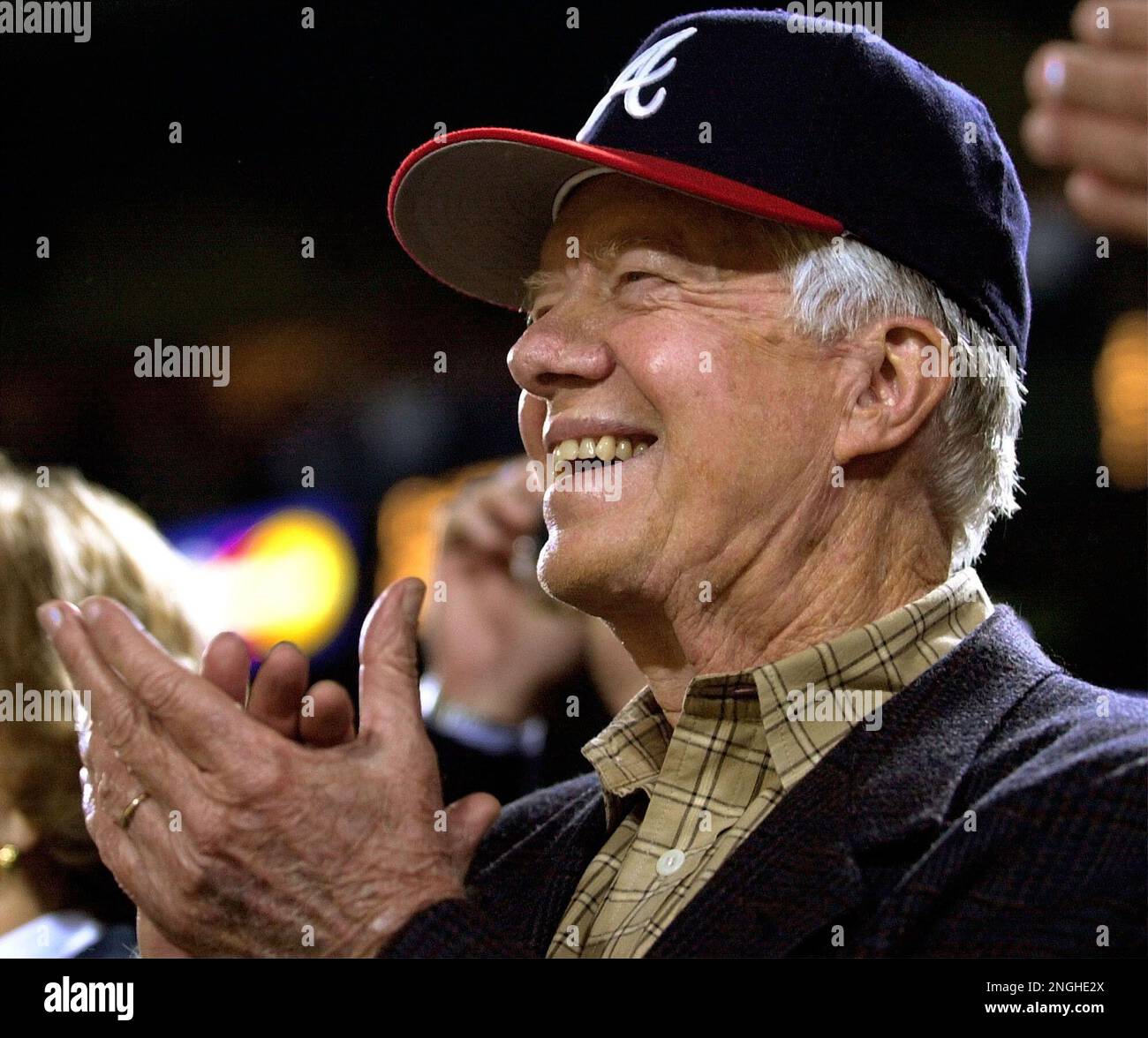 Atlanta Braves fan former President Jimmy Carter cheers during the seventh  inning stretch as a group sings God Bless America during Game 3 of the  National League Championship Series at Turner Field