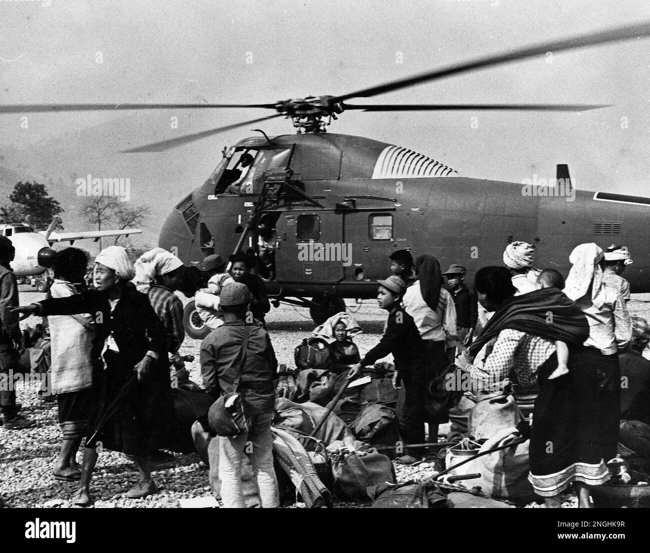 Meo refugees crowd around an Air America Helicopter, piloted by U.S.  civilian personnel, during the evacuation of Sam Thong base southwest of  the Plain of Jars, Laos on Tuesday, March 18, 1970. (