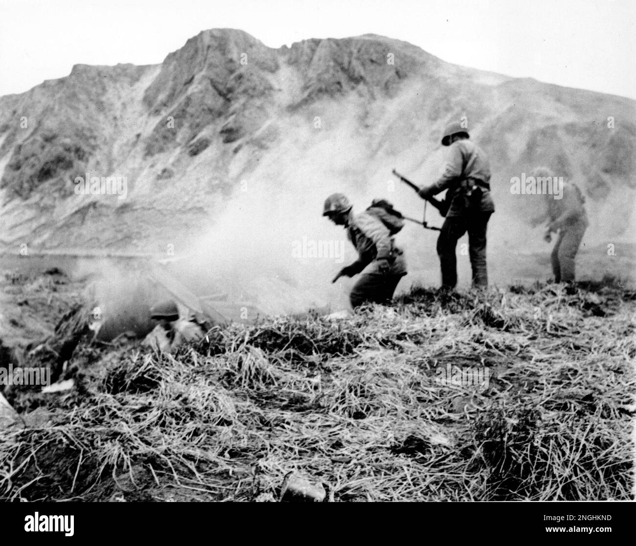 A U.S. squad armed with guns and hand grenades close in on Japanese