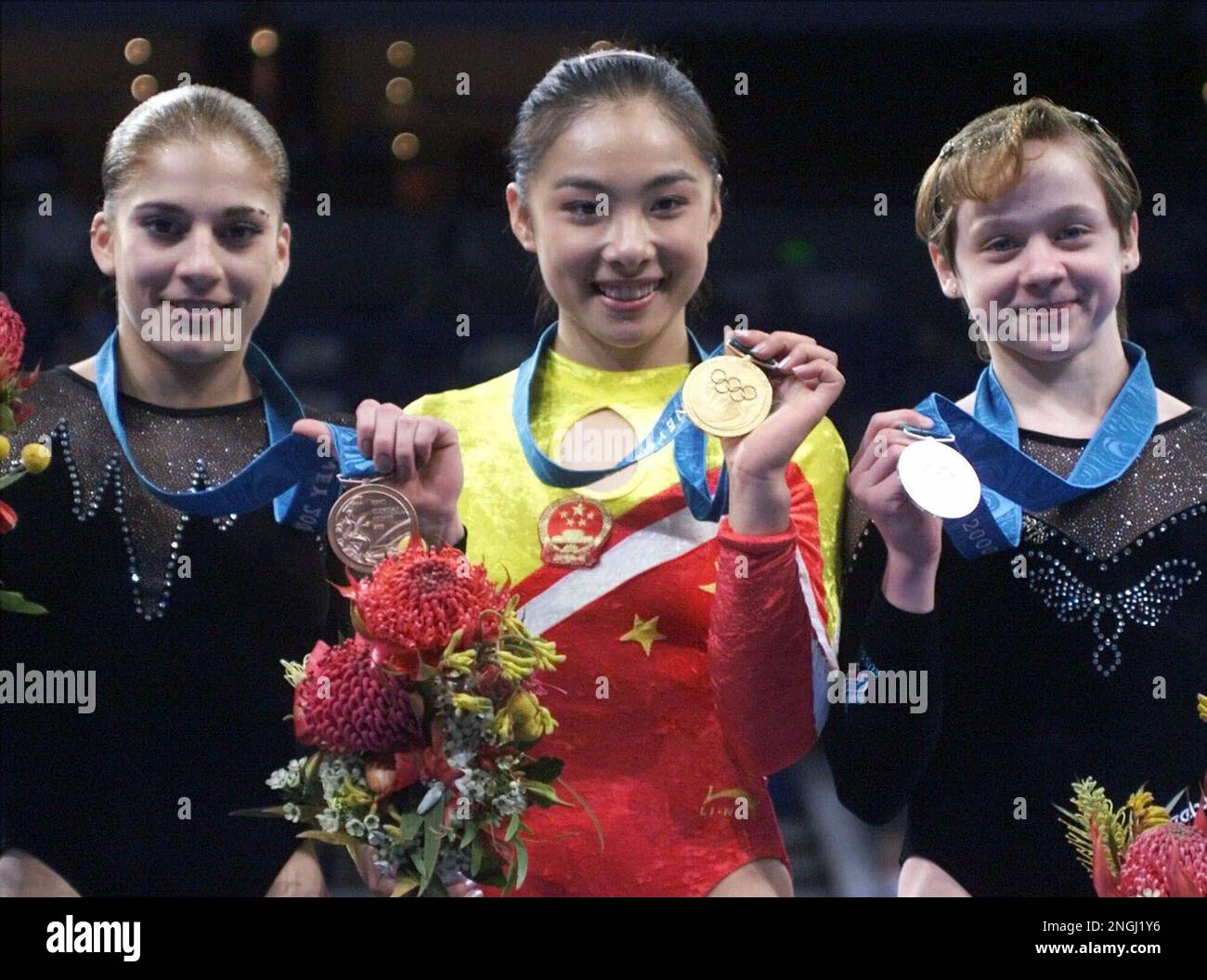Winners in the balance beam competition show of the medals during the