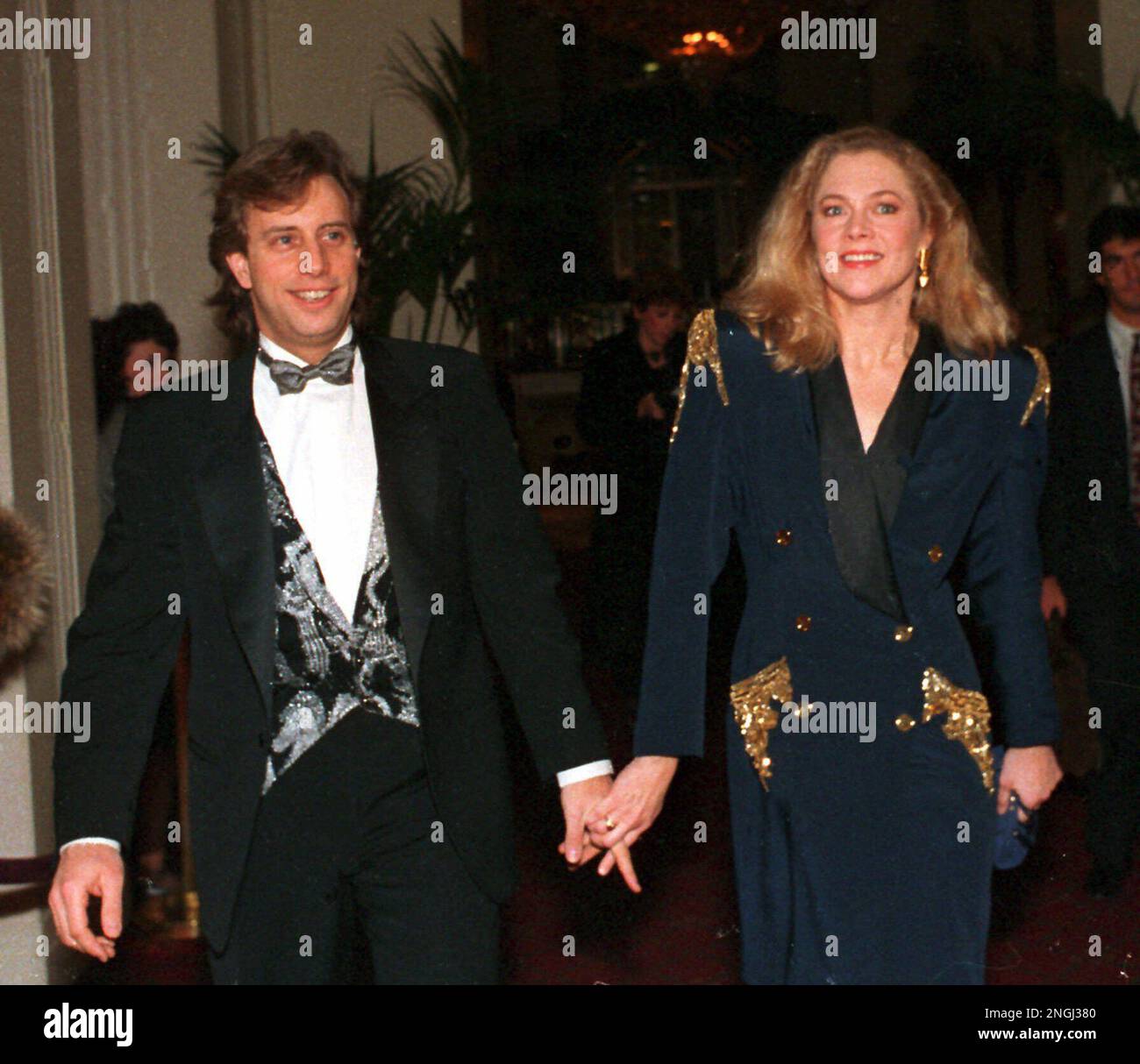 Actress Kathleen Turner holds hands with her husband, real estate