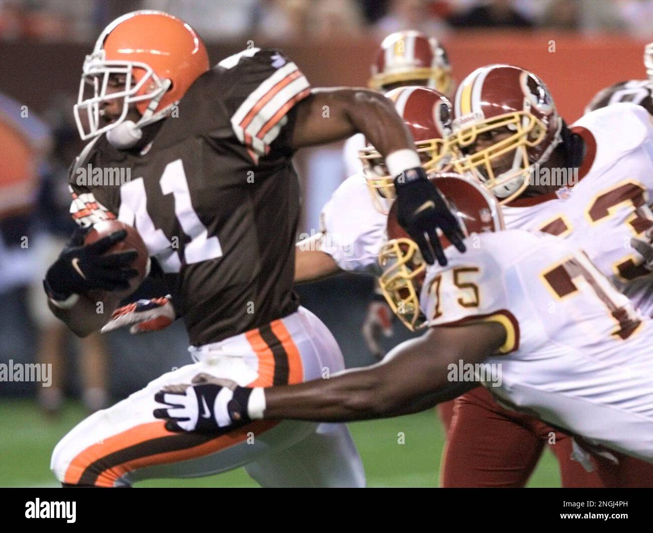 Cleveland Browns' Travis Prentice, left, runs for 8 yards before being  stopped by Washington Redskins' Derrick Ham, foreground right, during the  fourth quarter Saturday, Aug. 19, 2000, in Cleveland. The Redskins won