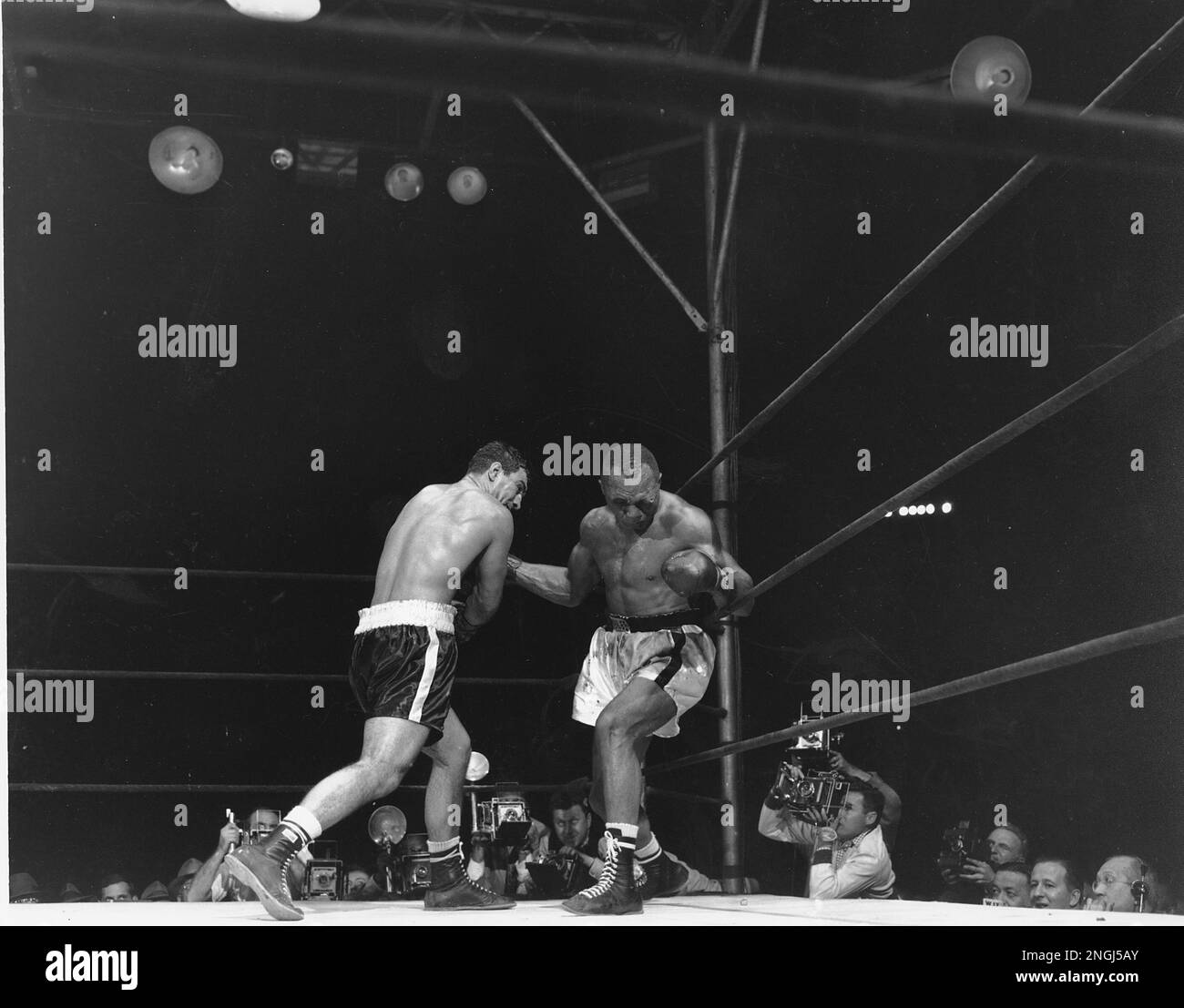 Jersey Joe Walcott buckles down against the ropes as Rocky Marciano