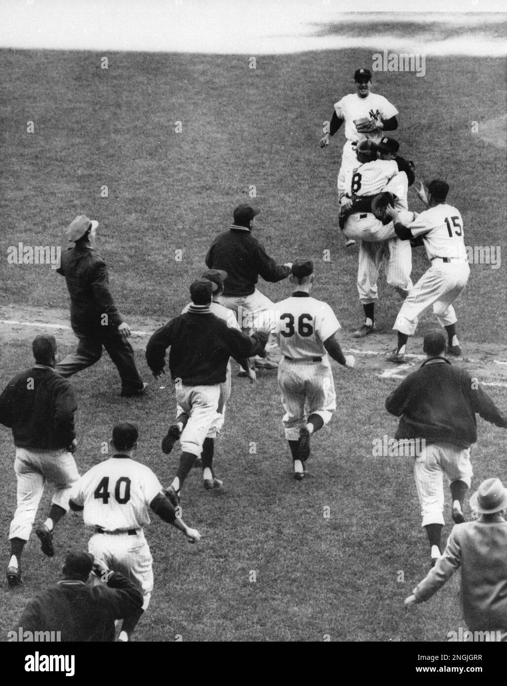 Catcher Yogi Berra (8) has jumped into the arms of pitcher Don