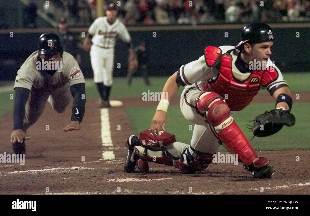 San Diego Padres' Ruben Rivera slides home as Atlanta Braves' Javy Lopez  waits for the ball in the eighth inning of the first game of the National  League Championship Series at Turner