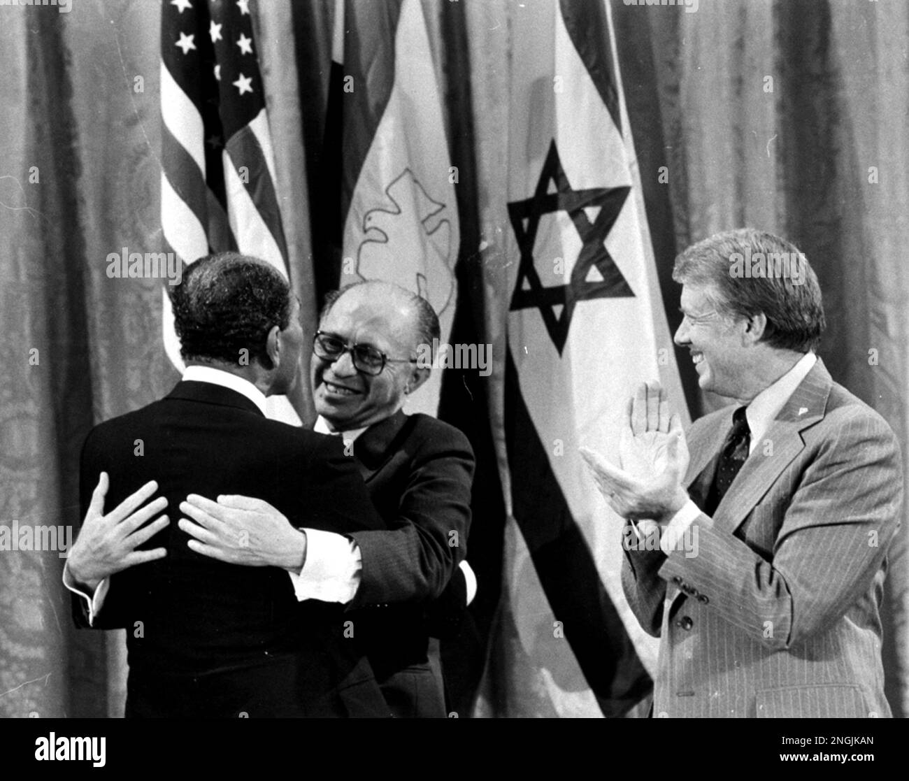 Egyptian President Anwar Sadat, left, and Israeli Prime Minister Menachem Begin, embrace as U.S. President Jimmy Carter looks on, September 18, 1978, during a White House announcement of a Middle East peace agreement reached at the Camp David Summit earlier this year. Sadat and Begin were named joint winners in the 1978 Nobel Peace Prize in an announcement Friday, October 27, from officials in Oslo, Norway. (AP Photo) Stock Photo