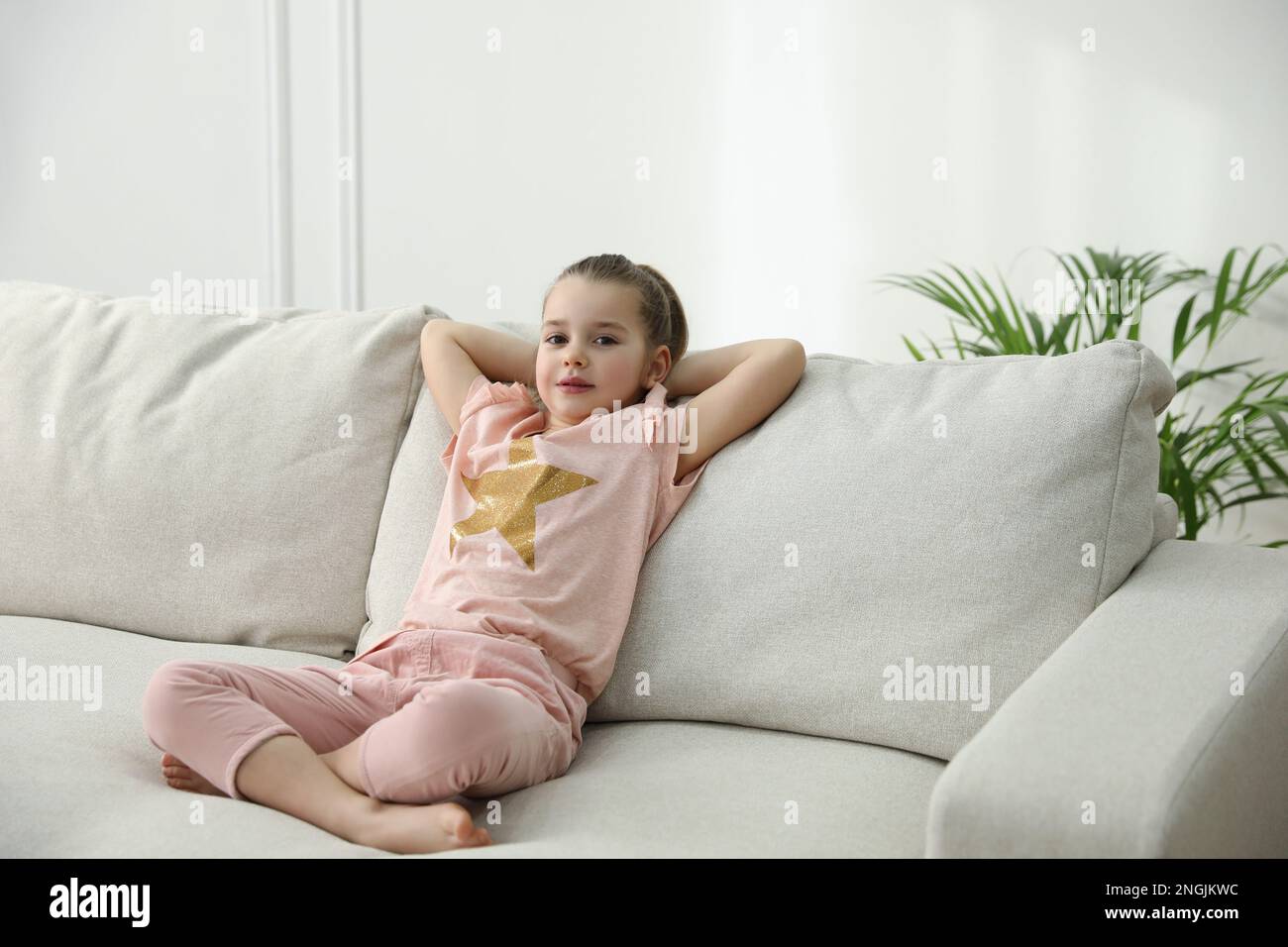 Little girl resting on comfortable sofa in living room Stock Photo - Alamy